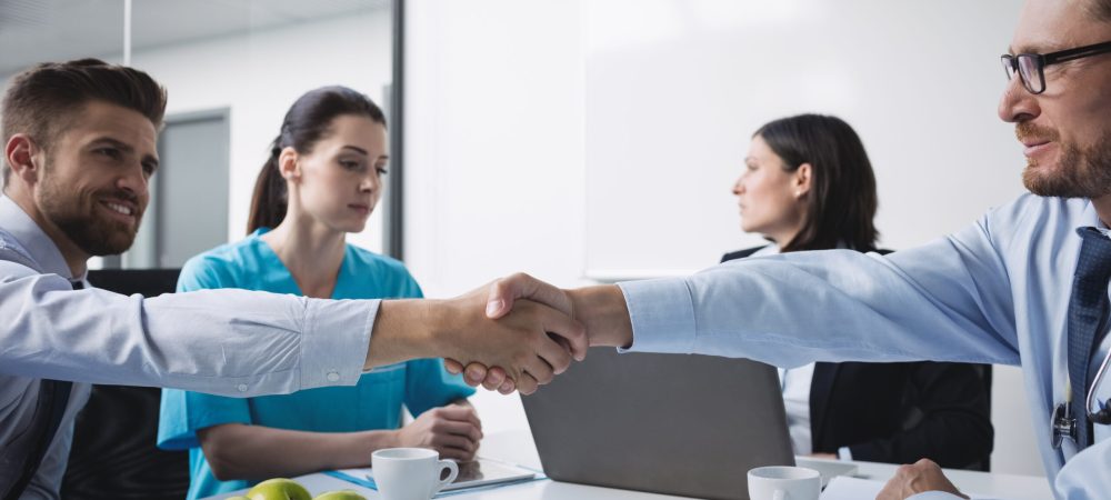 Doctors shaking hands with each other in meeting at conference room